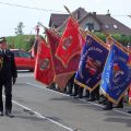 Strażacy salutujący do uchylonych sztandarów